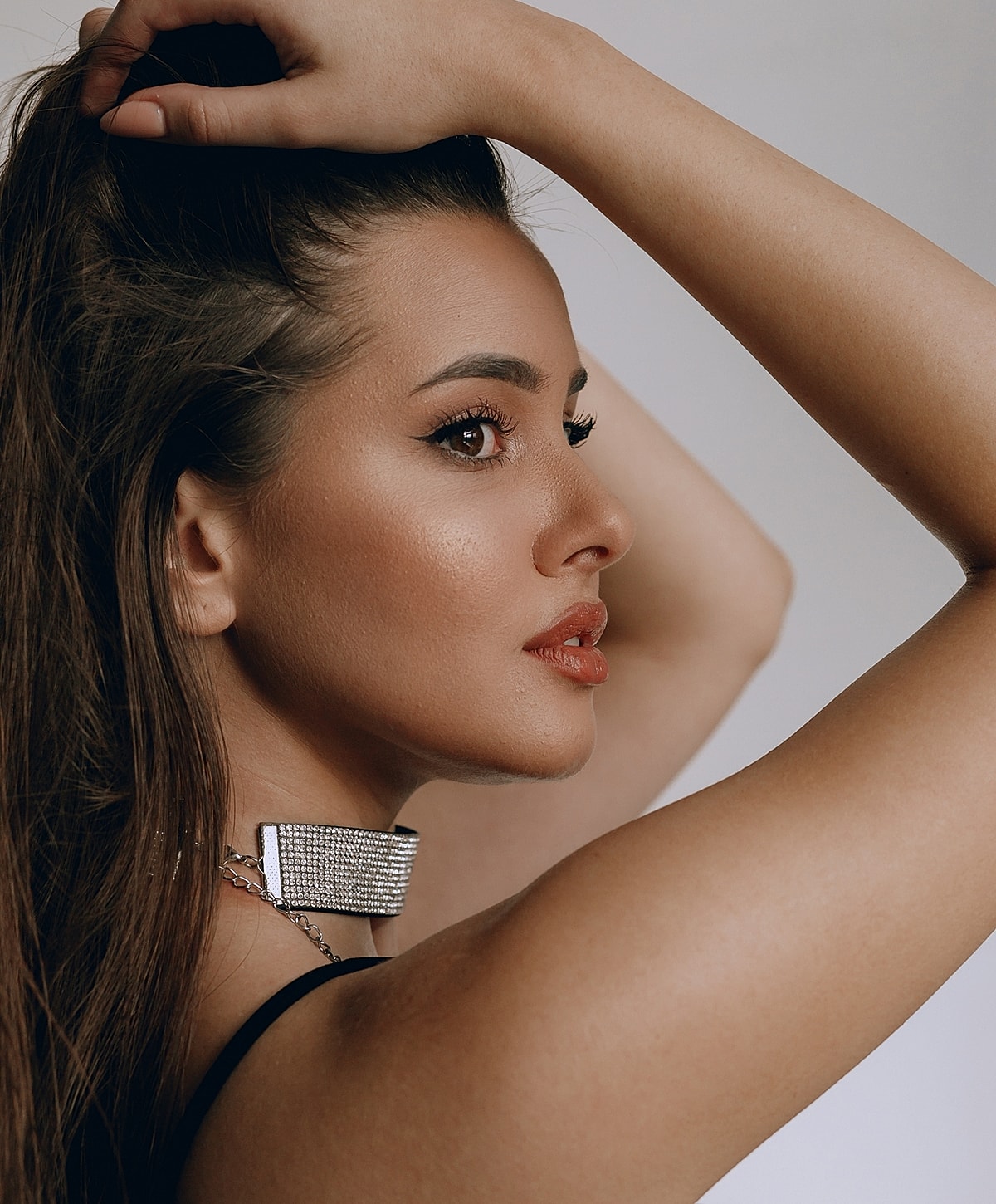 Profile of a woman with long hair and jewelry.