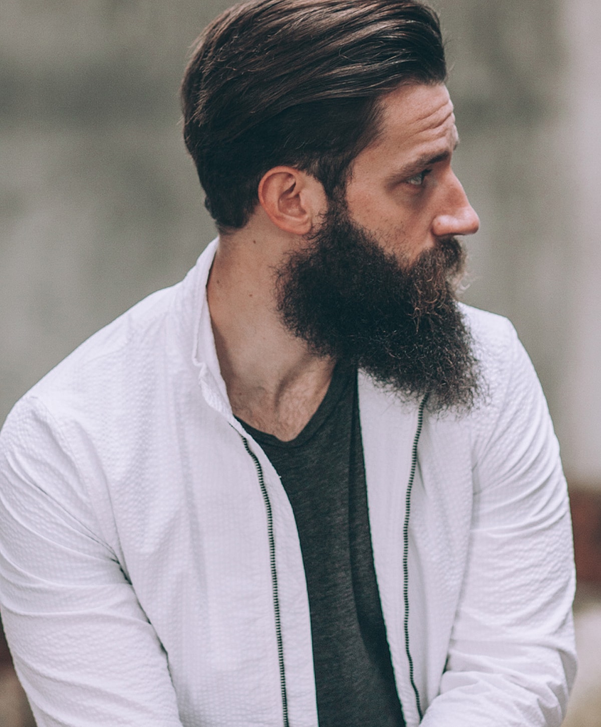 Man with beard and stylish haircut, profile view.