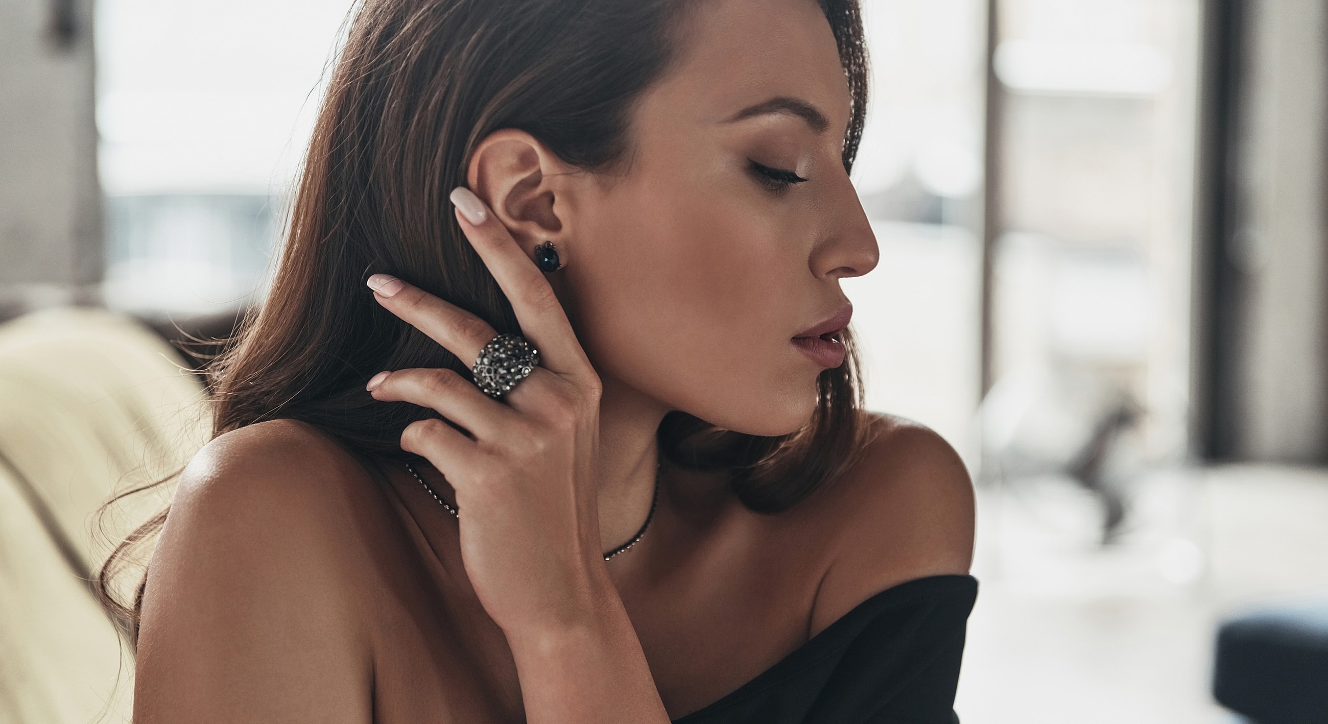 Woman showcasing elegant jewelry in profile view.